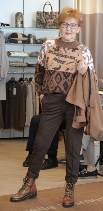 Braunes Outfit mit gemustertem Pullover, Cape und Stiefeln