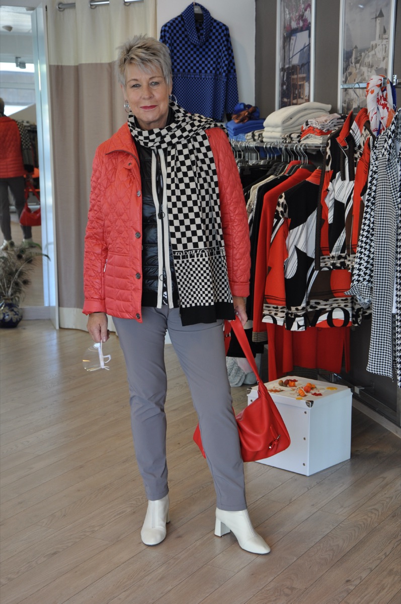 Kundin in roter Steppjacke mit schwarz-weiß gemustertem Schal